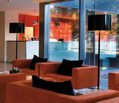 a lobby with orange furniture and a large window at Expo Congress Hotel in Budapest