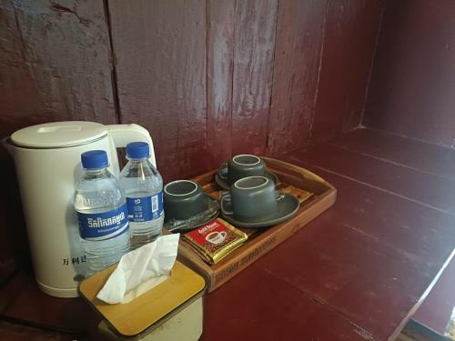 un vassoio con acqua e bicchieri e una bottiglia d'acqua di Roomy Bungalows a Phumĭ Kâoh Rŏng