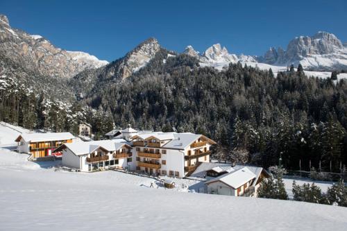 a resort in the snow with mountains in the background at Dolomitenhotel Weisslahnbad in Tires