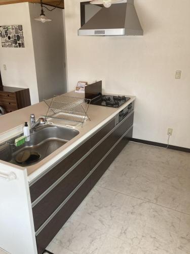eine Küche mit Spüle und Herd in der Unterkunft Cottage Akagera in Wada