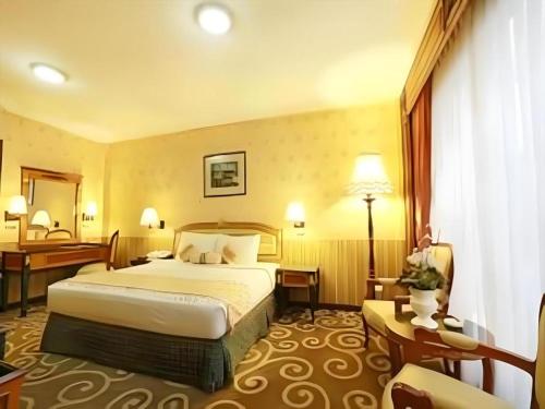 Postel nebo postele na pokoji v ubytování Gajahmada Graha Hotel