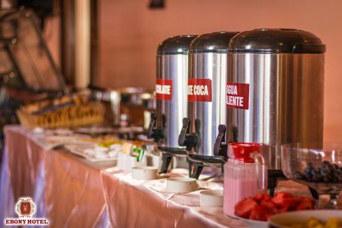 una línea de buffet con dos grandes tanques de plata sobre una mesa en Ebony Hotel, en Huaraz