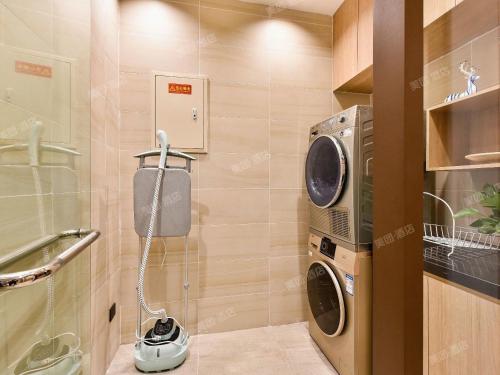 ein kleines Badezimmer mit Waschmaschine und Trockner in der Unterkunft Hanting Premium Hotel Beijing Daxing Jinxing Bridge Xingguang Film and Television City in Peking