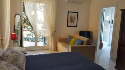 a bedroom with a bed and a couch and a window at B&B Massico Apartments in Sant'Agnello