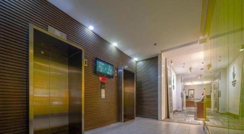 a hallway of a building with a elevator and a door at Jinjiang Inn Dalian Jiefang Road in Dalian