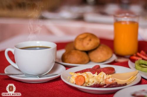 a table with a cup of coffee and a plate of food at Ebony Hotel in Huaraz
