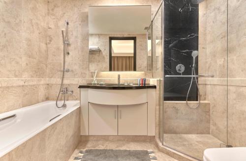a bathroom with a tub and a sink and a shower at Orchard Scotts Residences by Far East Hospitality in Singapore