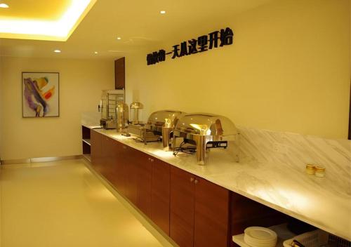 a kitchen with a counter with two sinks in it at City Comfort Inn Hengyang Dayang Department Lianhu Plaza in Hengyang