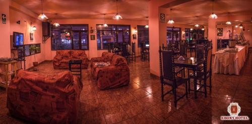 a living room with couches and a table and chairs at Ebony Hotel in Huaraz