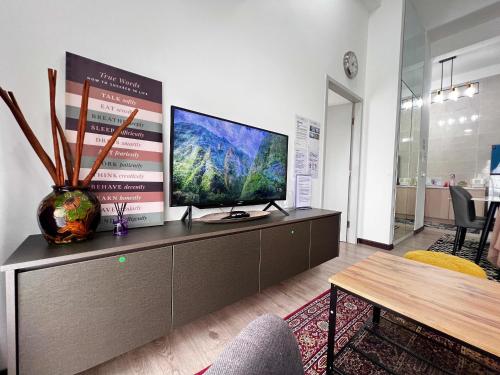 uma sala de estar com uma televisão de ecrã plano num armário em MySky Stays Putrajaya em Putrajaya