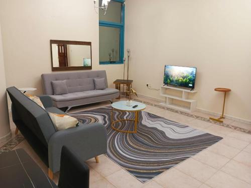 a living room with a couch and a tv at Splendid 3-Bedroom Apartment near Buhaira Corniche in Sharjah