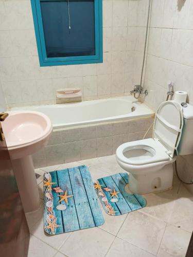 a bathroom with a toilet and a sink and a bath tub at Splendid 3-Bedroom Apartment near Buhaira Corniche in Sharjah