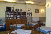 Hotel Castilla في أنتيكيرا: مطعم بطاولات وكراسي وساعة على الحائط
