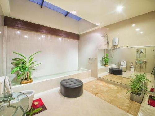 ein Badezimmer mit einer großen Dusche mit einem schwarzen Ottomanen in der Unterkunft Banter Resort in Ban Mai