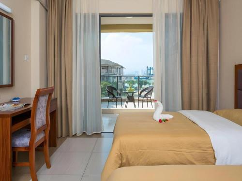 a hotel room with a bed with a swan toy on it at Mango Sea View Hotel in Sanya