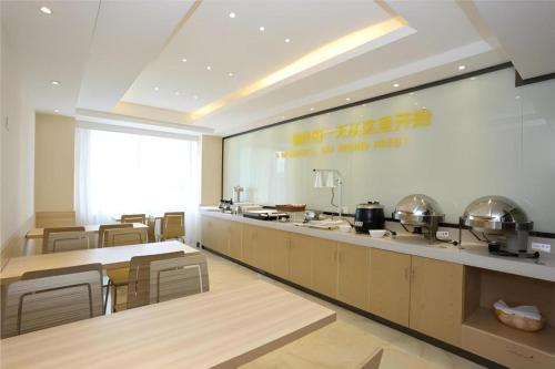 ein Restaurant mit einer großen Küche mit Tischen und Stühlen in der Unterkunft City Comfort Inn Changsha Tangshuili Fuyou in Changsha