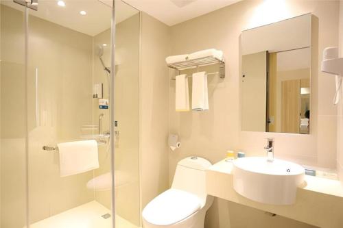 ein Badezimmer mit Waschbecken, Toilette und Dusche in der Unterkunft City Comfort Inn Changsha Tangshuili Fuyou in Changsha