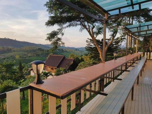 eine lange Holzterrasse mit Blick auf die Berge in der Unterkunft Jit Dee Home Khao Kho in Khao Kho