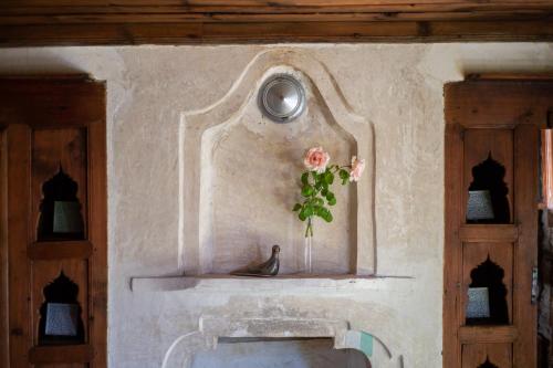 a wall with a vase with a flower in it at Gulevi Safranbolu Heritage Hotel in Safranbolu