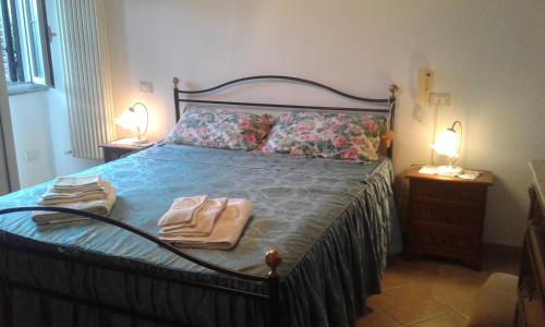 a bedroom with a bed with two towels on it at Da Lilly Apartment in Lucca