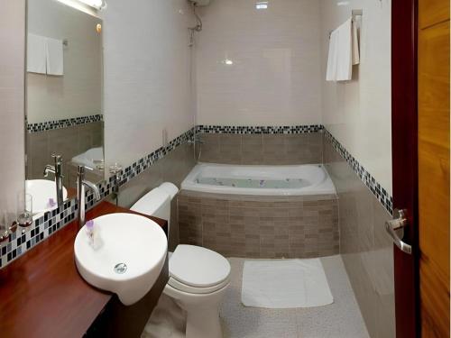 ein Badezimmer mit Badewanne, Toilette und Waschbecken in der Unterkunft Sao Mai Phu My Resort in Phú Mỹ
