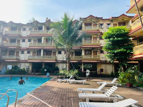 un hotel con piscina frente a un edificio en 2 BHK Appartment calangute, en Calangute