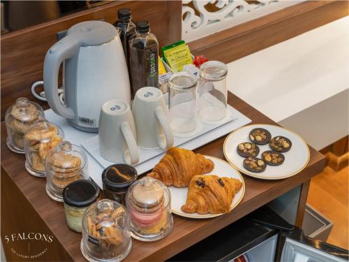 una mesa con dos platos de comida y una cafetera en 5 Falcons The Luxury Residency, en Srinagar