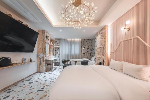 ein Hotelzimmer mit einem großen Bett und einem Kronleuchter in der Unterkunft Daegu February Hotel Lions Park in Daegu