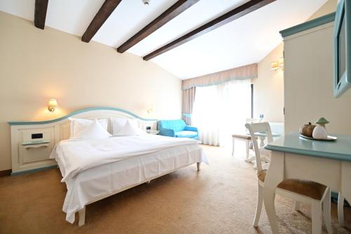 ein Schlafzimmer mit einem großen weißen Bett und einem Schreibtisch in der Unterkunft Natura Family Resort in Avrig