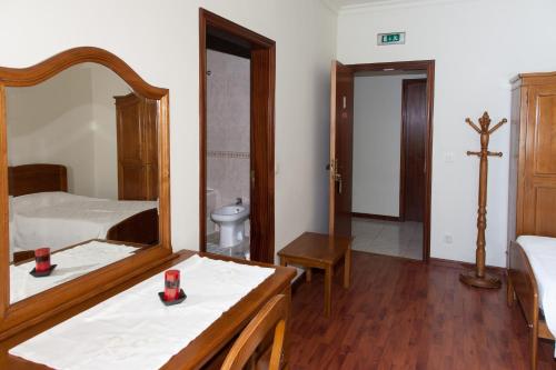 a bedroom with a bed and a dresser at Residencial o Trindade in Águeda