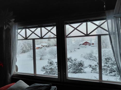ein Fenster mit Blick auf einen schneebedeckten Hof in der Unterkunft A room (or 2 or 3) in a Lapland House of Dreams in Rovaniemi