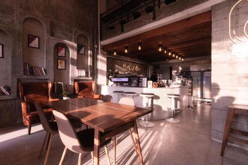 ein Esszimmer mit einem Holztisch und einer Bar in der Unterkunft The Singha Hotel - Korat in Ban Nong Chabok