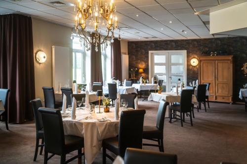 une salle à manger avec tables et chaises et un lustre dans l'établissement Ahauser Landhotel, à Alstätte