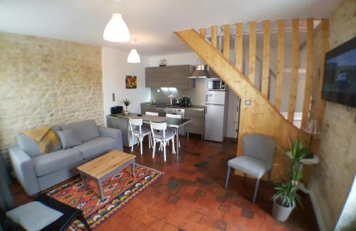 a living room with a couch and a table and a kitchen at Maisoun Pequeux in Arromanches-les-Bains