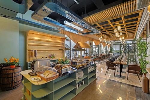 een restaurant met een buffet met tafels en stoelen bij Hays AIR By Ahuja Residences - Golf Course Ext Road & Sector 51 in Gurgaon