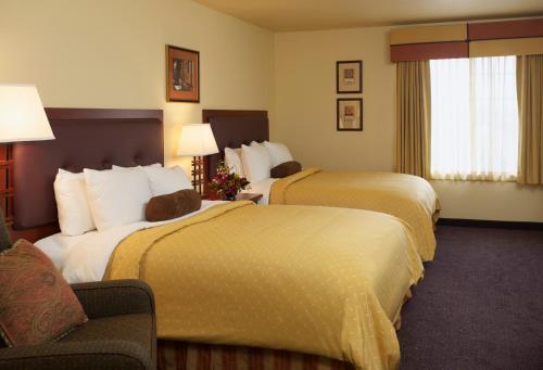 ein Hotelzimmer mit 2 Betten und einem Stuhl in der Unterkunft Larkspur Landing Roseville-An All-Suite Hotel in Roseville