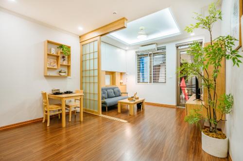 a living room with a couch and a table at XÔI Setai Suites Linh Lang in Hanoi