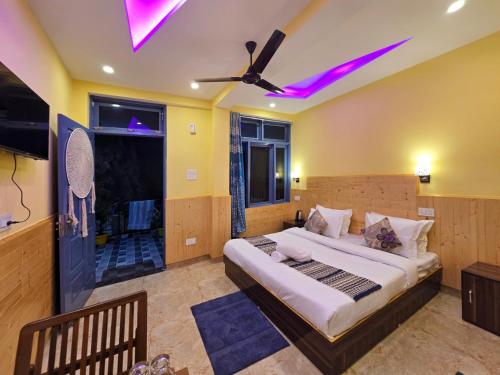 ein Schlafzimmer mit einem großen Bett und einem Deckenventilator in der Unterkunft Aangan Royal Stay- Your Mountain Home in Dharamshala in Dharamsala