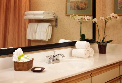 a bathroom with a sink and a mirror and towels at Larkspur Landing Roseville-An All-Suite Hotel in Roseville