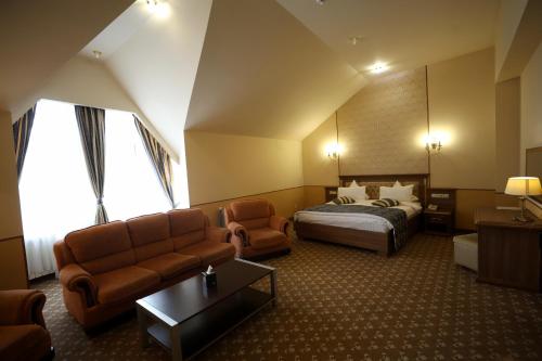 una habitación de hotel con una cama y un sofá en Multi Rest House, en Tsaghkadzor