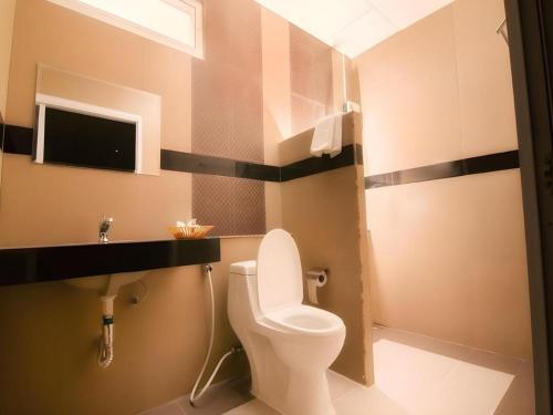 ein Badezimmer mit Toilette und Waschbecken in der Unterkunft The Premium Residence in Roi Et