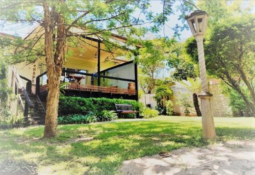una casa con porche y una lámpara en el patio en Green Trees Cottage, en Nelspruit