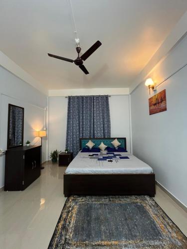 a bedroom with a bed with a ceiling fan at Puhor Inn in Sivasagar