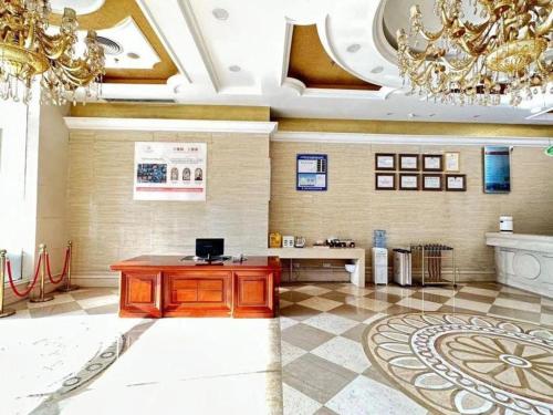 Großes Zimmer mit einem Tisch und einem Kronleuchter in der Unterkunft Vienna Hotel Shenzhen International Exhibition Center Fuhai Qiaotou in Fenghuangwei