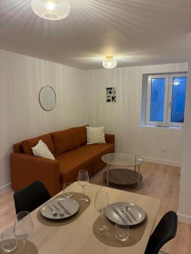 a living room with a couch and a table with wine glasses at Appartement Chic 4 personnes - Plein Centre Historique in Angers