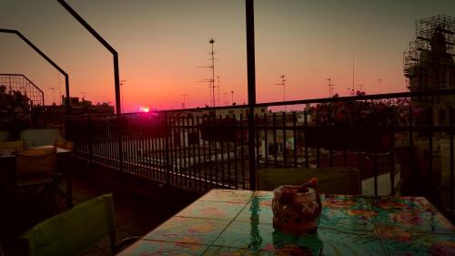 a table on a balcony with a sunset in the background at Attico Barocco in Lecce