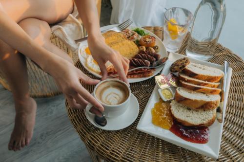 Una mesa con un plato de desayuno y una taza de café. en Solea Seaview Resort, en Mactan