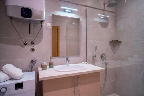 Un baño con lavabo y ducha en Budva Wow Apartments, en Budva