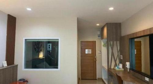 ein Wohnzimmer mit weißen Wänden und einem Spiegel in der Unterkunft Hotel Le Lerts Living in Khon Kaen