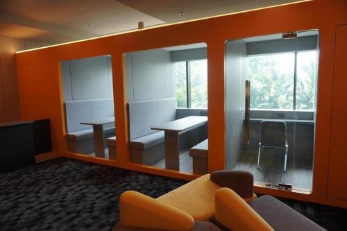 Habitación con paredes de color naranja, sofá y mesa. en NapzBox, en Petaling Jaya
